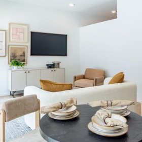 a living room with a tv and chairs