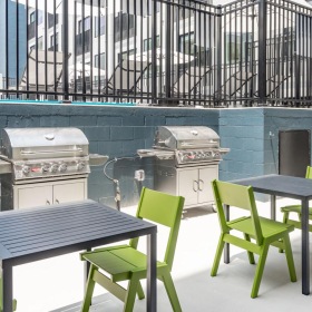 a grill area with tables and chairs outside